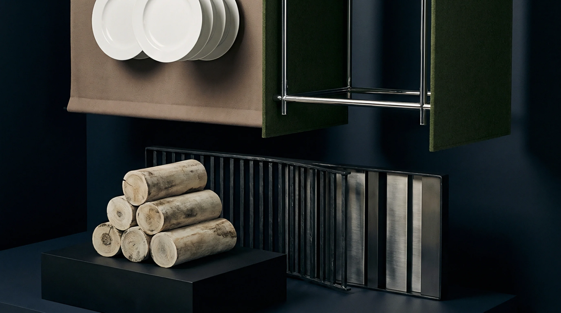 Cylindrical wood fuel logs rest beside a vertical metal slat grid on a dark surface beneath felt fabric panels and ceramic dinnerware.