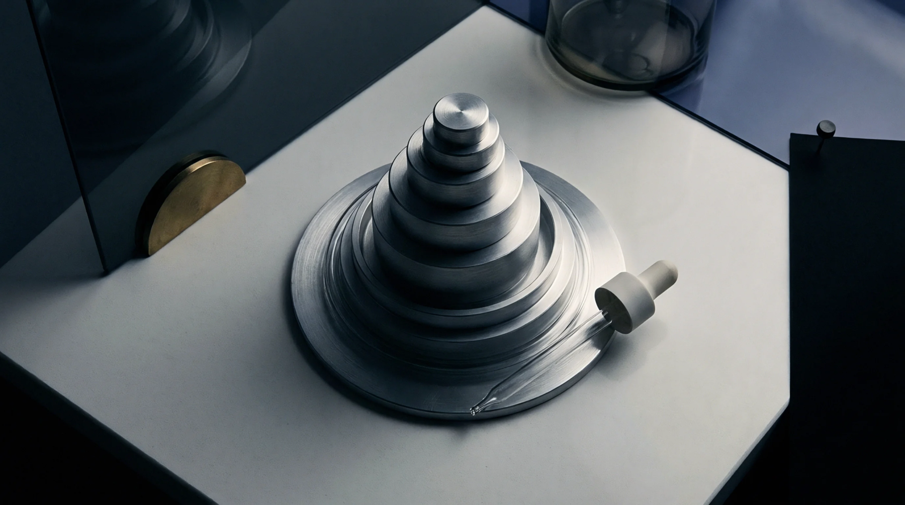 Stacked aluminum calibration discs and a precision dispensing pipette rest on a white surface inside a manufacturing studio.